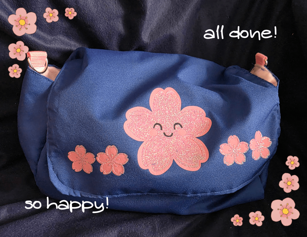 a picture of a royal blue purse with light pink cherry blossoms overlaid with glitter on the flap